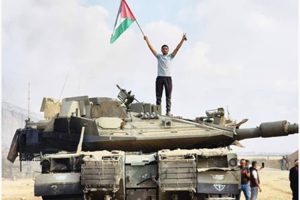 مواطن يرفع العلم الفلسطيني فوق دبابة اسرائيلية